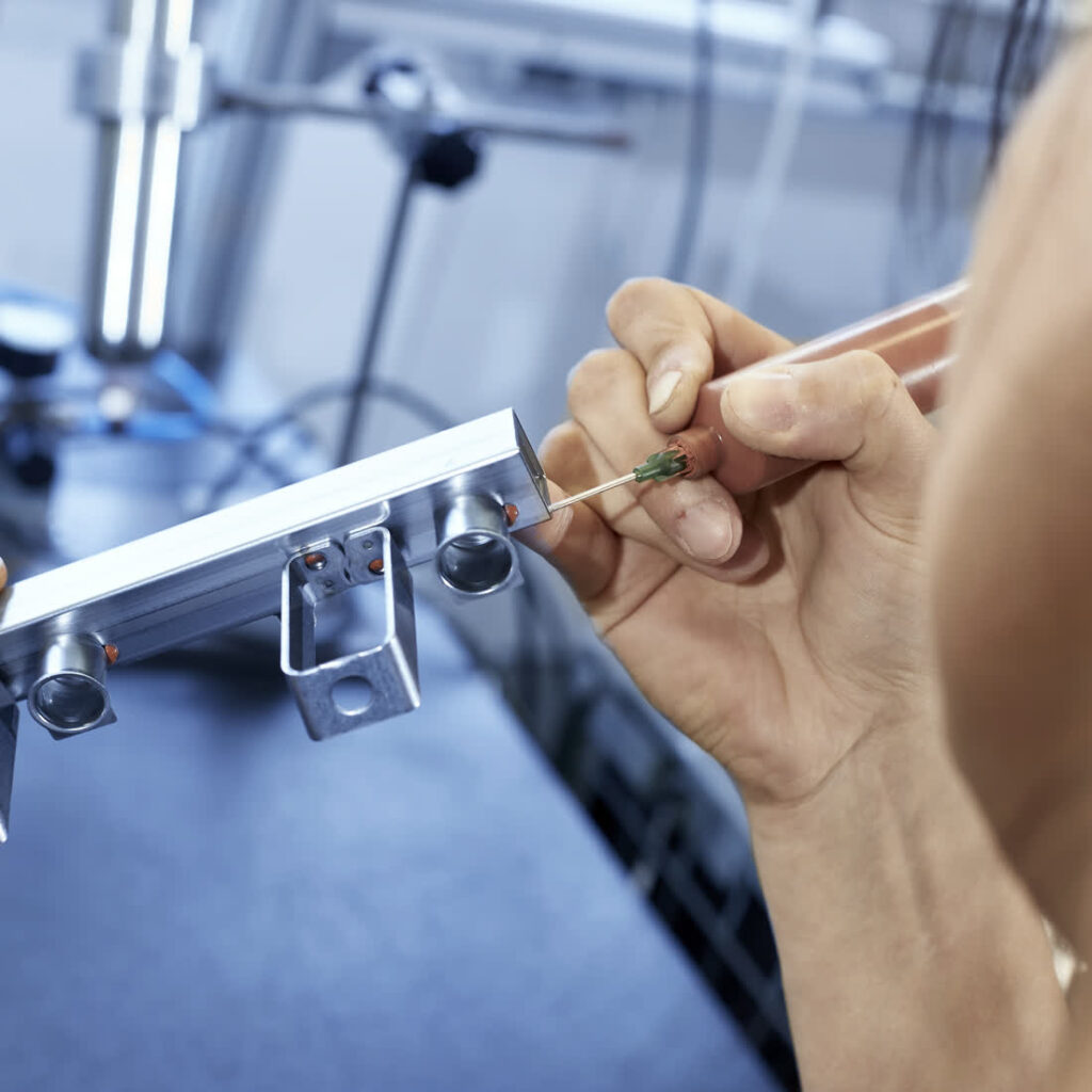 Belotung eines Aluminiumprofils: Lotring wird zur Lötvorbereitung von Hand aufgesetzt