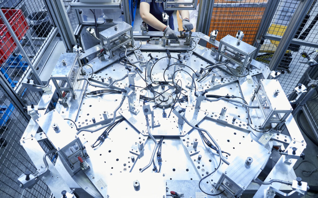 Rotary indexing table of an induction brazing system, loaded with metal pipe assemblies clamped in a star pattern