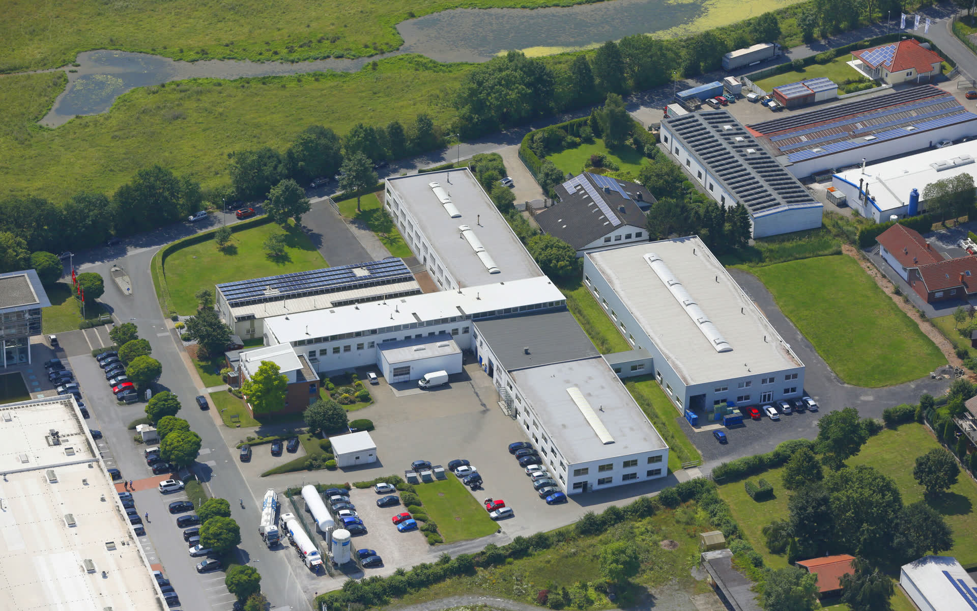 Luftbild vom Standort Harnischmacher mit Produktionshallen, Solardach und Parkplätzen