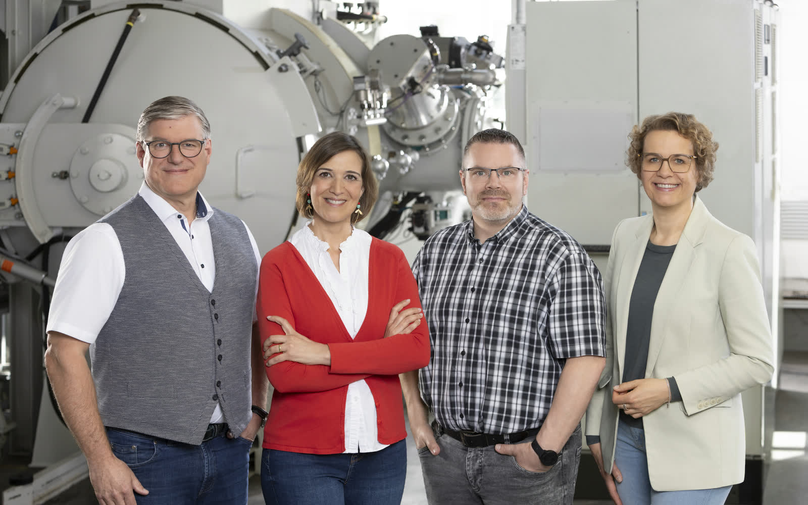 Vierköpfiges Vertriebsteam als Ansprechpartner vor industrieller Vakuumlötanlage